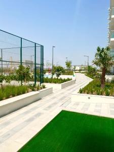 a garden with a green lawn in a building at Gorgeous Apt In DAMAC HILLS - Golf View in Dubai