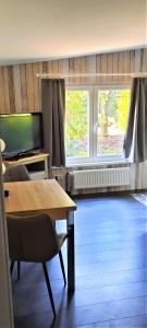 a living room with a table and two windows at Kleiner Bungalow Am Wald in Petershagen