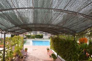 szklany dach nad patio z ławkami i basenem w obiekcie GEMELOS2 Loysan apt. with pool w mieście Benidorm