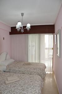 sypialnia z 2 łóżkami i żyrandolem w obiekcie GEMELOS2 Loysan apt. with pool w mieście Benidorm +33 zdjęcia