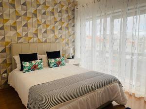 a bedroom with a bed and a large window at CASA MR in Nazaré