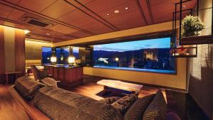 a living room with a couch and a large window at Sora Niwa Terrace Kyoto Bettei in Kyoto