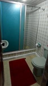 a bathroom with a toilet and a glass shower at CASA LATINO in Bogotá