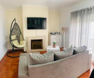 Una sala de estar con un sofá y una chimenea. en CASA MR, en Nazaré