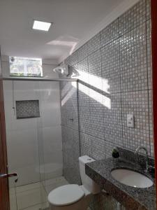 a bathroom with a toilet and a shower and a sink at pousada Montanhez ap5 in Alto Caparao