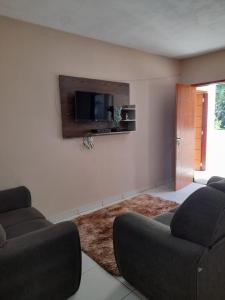 ein Wohnzimmer mit 2 Sofas und einem Flachbild-TV in der Unterkunft hospedagem recanto do sábia 5 in Caparaó Velho