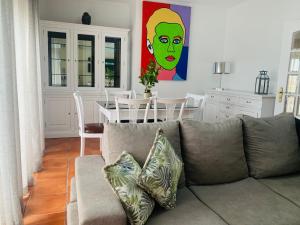 ein Wohnzimmer mit einem Sofa und einem Tisch mit einem Gemälde in der Unterkunft CASA MR in Nazaré
