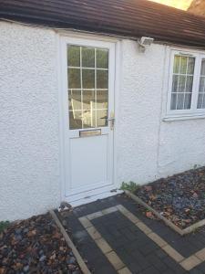 a white door of a white house with a window at Chantilly in Ickenham
