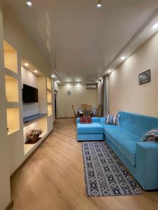 a living room with a blue couch and a table at LT-Home in Tbilisi City