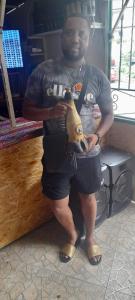 Un uomo in piedi in un negozio con un idrante di Pam de Terra a Calheta
