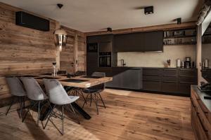 cocina con suelo de madera, mesa y sillas en Cozy Loft in the Alps of Zillertal, en Schwendau