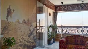 een woonkamer met een bank en een schilderij aan de muur bij Giza Pyramids View Guest house in Caïro