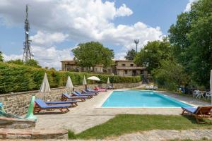 a swimming pool with lounge chairs and a resort at Agriturismo Casanova in Gubbio