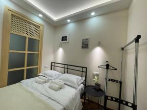 a bedroom with a bed with white sheets and a window at LT-Home in Tbilisi City