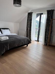 1 dormitorio con 1 cama y suelo de madera en Transylvania House, en Moieciu de Jos