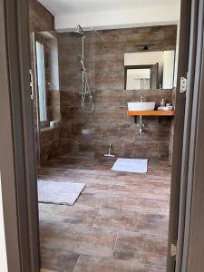 ein Bad mit einer Dusche und einem Waschbecken in der Unterkunft Transylvania House in Moieciu de Jos