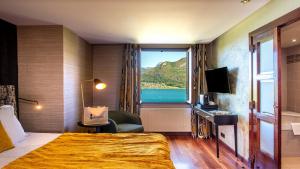 a hotel room with a bed and a window at Les Trésoms Lake and Spa Resort in Annecy