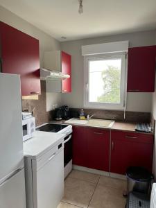 a kitchen with red and white cabinets and a window at Magnolia58 in Pontault-Combault