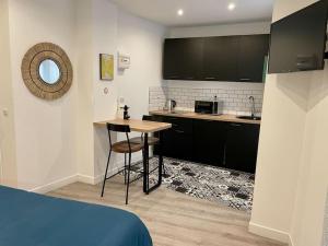 małą kuchnię ze stołem w pokoju w obiekcie Le Moulin 3 - Appartement Tout Confort Centre Ville - Beziers - Wifi - Tv connecté w Béziers