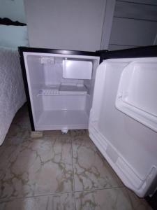 un frigorifero vuoto con la porta aperta in una stanza di HABITACION CERCA DE LA UNIVERSIDAD DEL Sinu a Cartagena de Indias