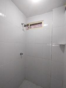 a white bathroom with a shower and a window at HABITACION CERCA DE LA UNIVERSIDAD DEL Sinu in Cartagena de Indias