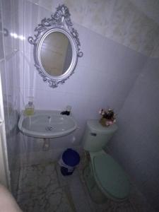 W łazience znajduje się umywalka, toaleta i lustro. w obiekcie HABITACION CERCA DE LA UNIVERSIDAD DEL Sinu w mieście Cartagena de Indias