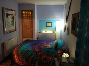 a bedroom with a bed with a colorful blanket at Hotel Rural Finca Liceo in Mijares