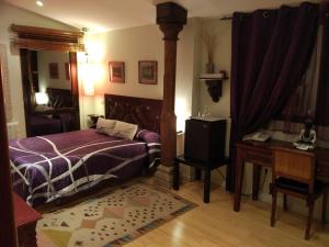 een slaapkamer met een bed, een tafel en een bureau bij Hotel Rural Finca Liceo in Mijares