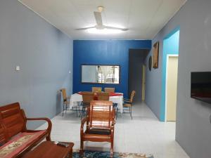 uma sala de jantar com paredes azuis e uma mesa e cadeiras em Jerai Geopark Cottage 3 bedrooms -Pulau Bunting em Yan