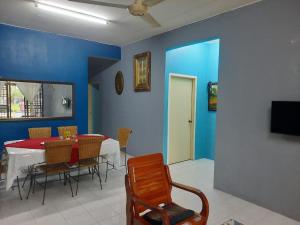 uma sala de jantar com mesa e cadeiras e uma parede azul em Jerai Geopark Cottage 3 bedrooms -Pulau Bunting em Yan
