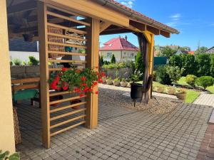 Rovinka的住宿－Rovinka Apartmán Petátos，木凉亭,带长凳和红色鲜花