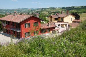 ein rotes Haus auf einem Hügel in der Unterkunft Cascina La Romana in Dogliani