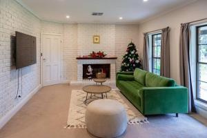 a living room with a green couch and a christmas tree at Furche Barossa Vineyard Family Stay in Dorrien