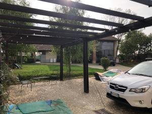 a pergola with a white car parked under it at Agriturismo la Longa in Poirino