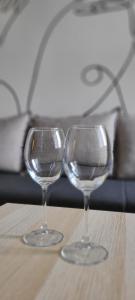 two empty wine glasses sitting on a wooden table at Cozy studio apartment at center of Bijeljina in Bijeljina