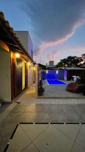 邦比尼亞斯的住宿－Pousada Casa Mariscal，一座房子的后院,晚上有一座游泳池