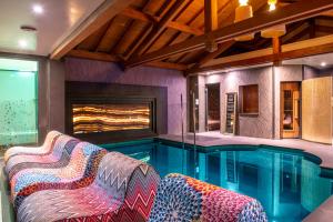 a swimming pool with two chairs in a house at Les Tr&eacute;soms Lake and Spa Resort in Annecy