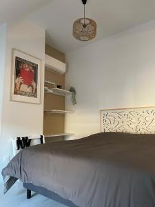 een slaapkamer met een bed met een grijze sprei bij Studio Saint Ayoul in Provins