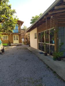 a house with a gravel driveway next to a building at Residencial Álacre casa e cabana aluguel Ferrugem SC in Garopaba