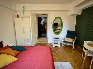 ein Schlafzimmer mit einem Bett, einem Spiegel und einem Stuhl in der Unterkunft MAYAHouse in Bukarest