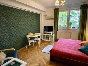 MAYAHouse في بوخارست: غرفة نوم بسرير وطاولة مع كراسي