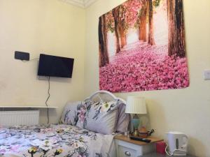 倫敦的住宿－TDM Bachelot Lettings Ltd，卧室配有一张床,墙上挂有绘画作品
