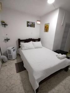 ein Schlafzimmer mit einem großen weißen Bett in einem Zimmer in der Unterkunft HABITACION CERCA DE LA UNIVERSIDAD DEL Sinu in Cartagena de Indias