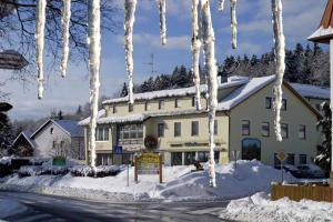 a building with icicles hanging from it in the snow at Hotel-Pension Würzbauer in Spiegelau