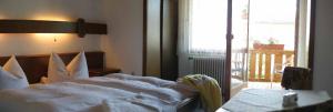 ein Bett ohne Außenwände in einem Schlafzimmer mit Balkon in der Unterkunft Hotel-Pension Würzbauer in Spiegelau