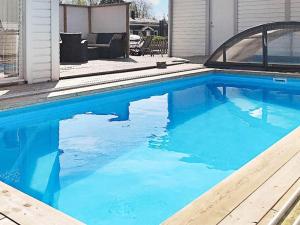 a swimming pool with blue water in a yard at Holiday home Björklinge in Björklinge