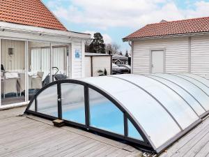 a pool deck with a glass bridge on a house at Holiday home Björklinge in Björklinge