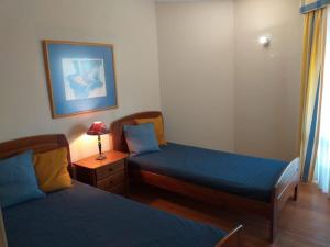 um quarto com duas camas e uma mesa com um candeeiro em Relax Beach Home - Costa de Caparica - Sea View em Costa da Caparica