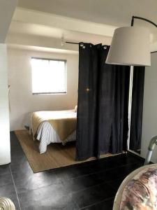 a bedroom with a bed with black curtains and a window at Cute and Quirky Doves Nest Studio Walk to Werri Beach in Gerringong