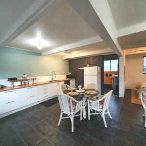 a kitchen and dining room with a table and chairs at Cute and Quirky Doves Nest Studio Walk to Werri Beach in Gerringong